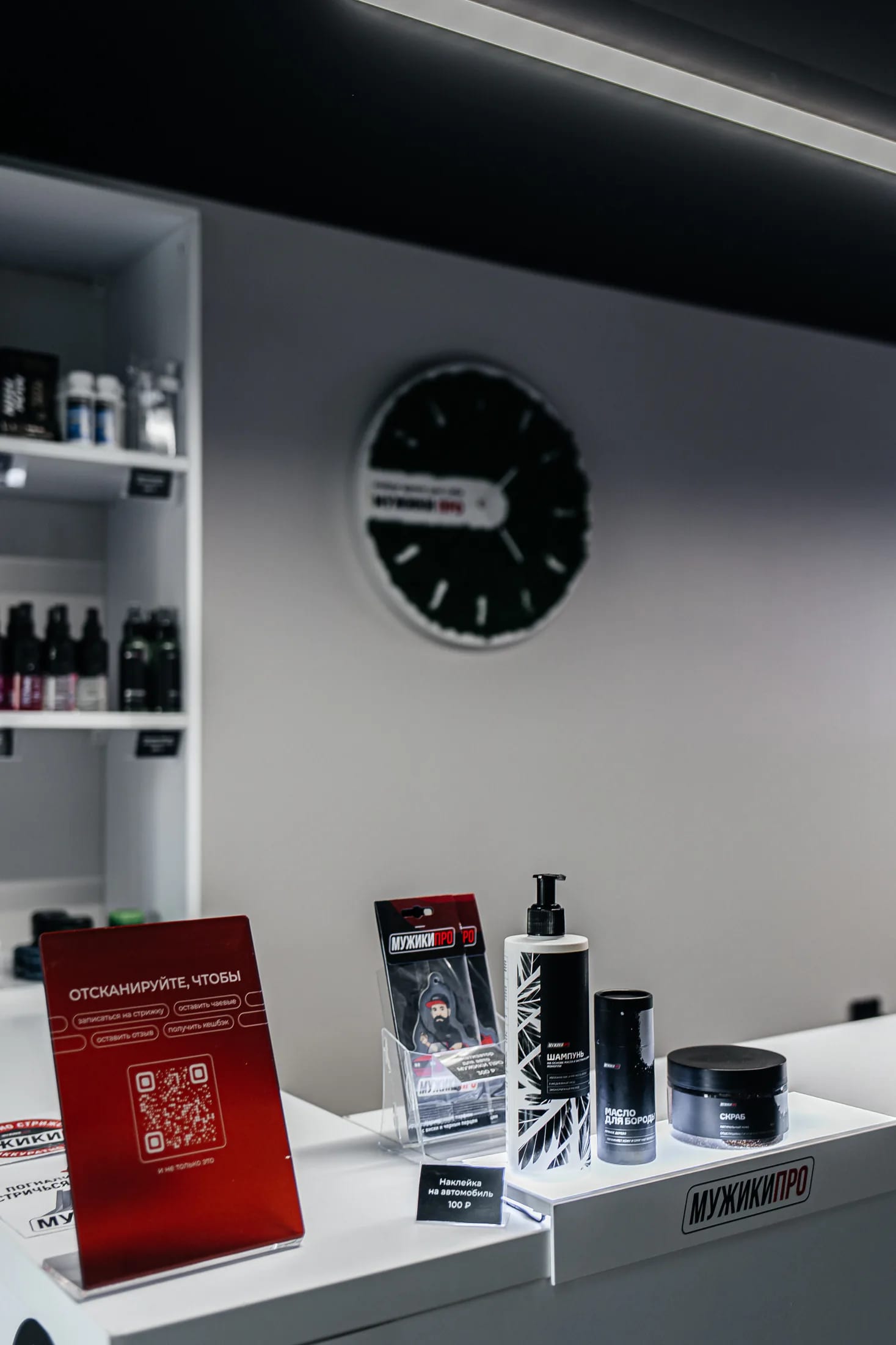 Витрина мужской косметики МУЖИКИ ПРО — шампунь, масло для бороды и скраб на стойке барбершопа в Тюмени