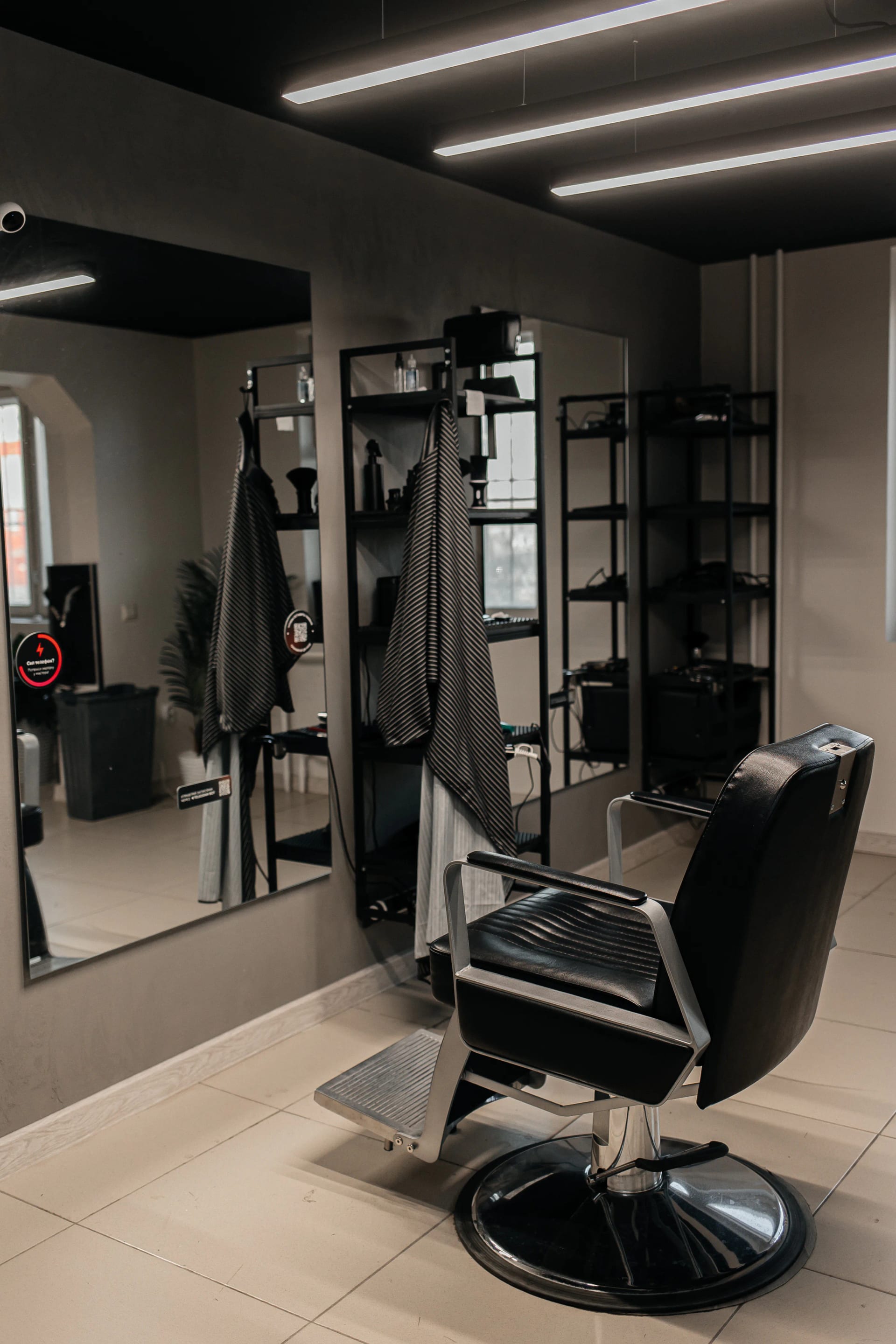 Рабочее место барбера в МУЖИКИ ПРО Тюмень — кресло, зеркало и инструменты в современном интерьере